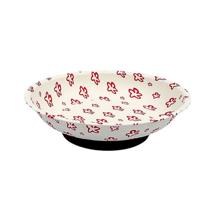 A white bowl with a red floral pattern, displayed on a black stand against a plain white background.