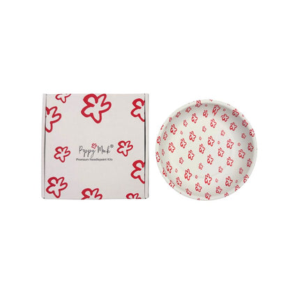 A white dish with a poppy pattern next to a closed box