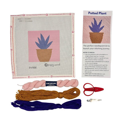 A needlepoint kit with an aloe in a pot, threads, and scissors