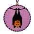 A Halloween needlepoint design of a pumpkin in a bat costume, finished as an ornament