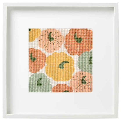 Framed needlepoint with pumpkins on a white background