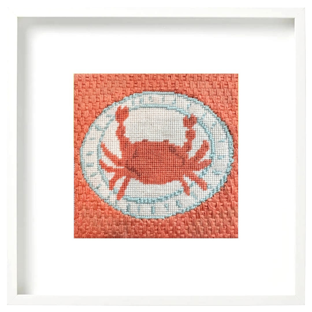 a framed needlepoint crab design