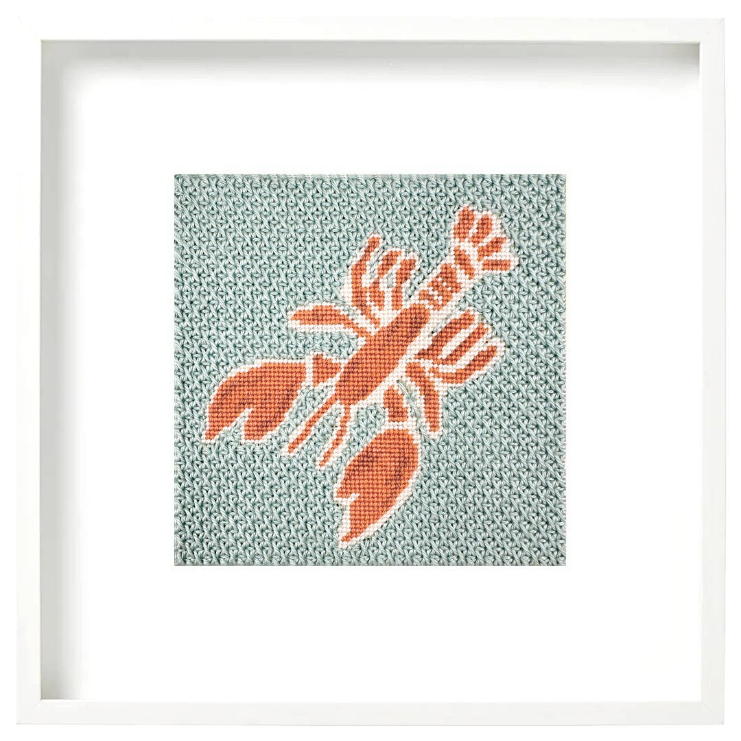 Lobster needlepoint design in a white frame