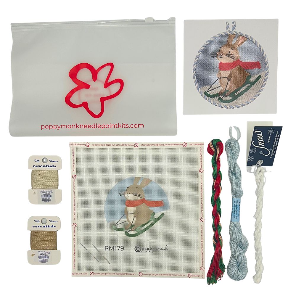 Needlepoint kit of a sledding hare with threads