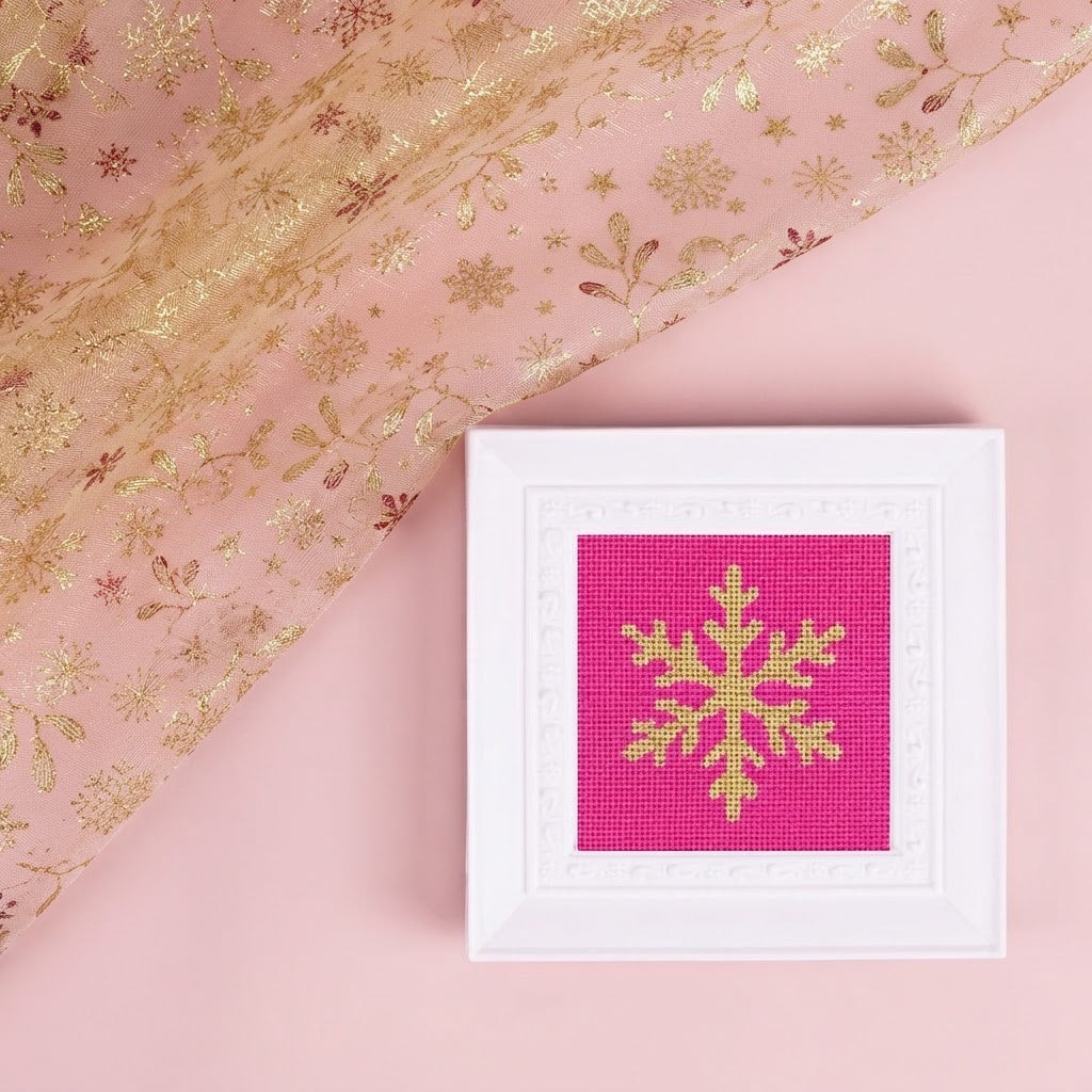 Snowflake needlepoint design in a white frame
