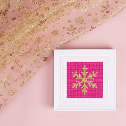 Snowflake needlepoint design in a white frame