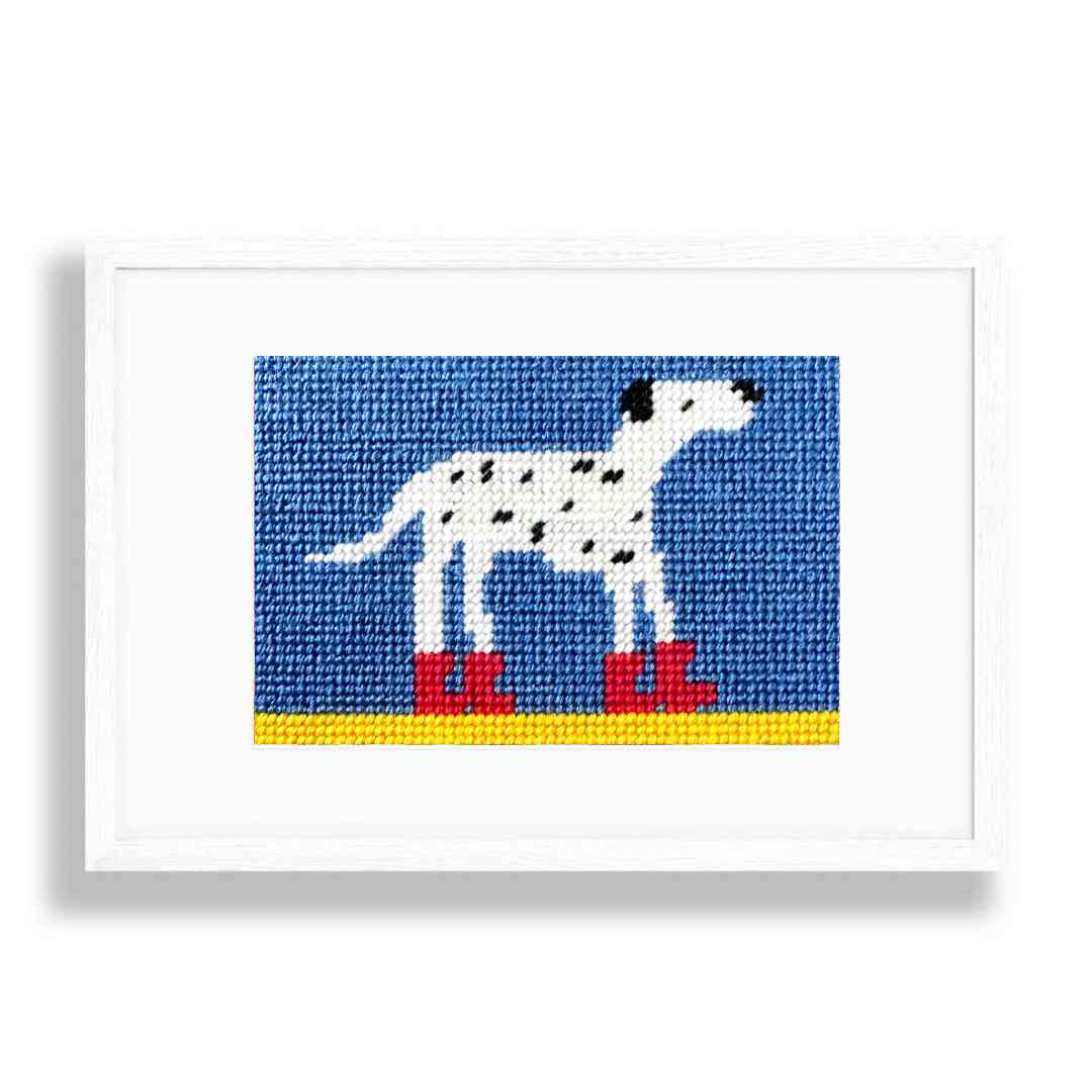 Framed needlepoint of a dalmatian dog with red boots on a blue background
