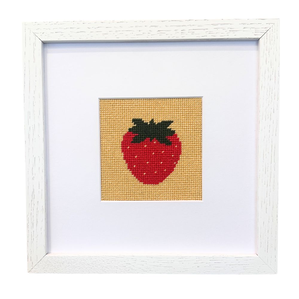 Framed needlepoint strawberry on a white background