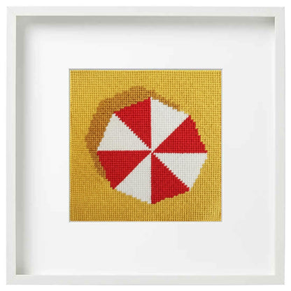 needlepoint design o an umbrella in a white frame
