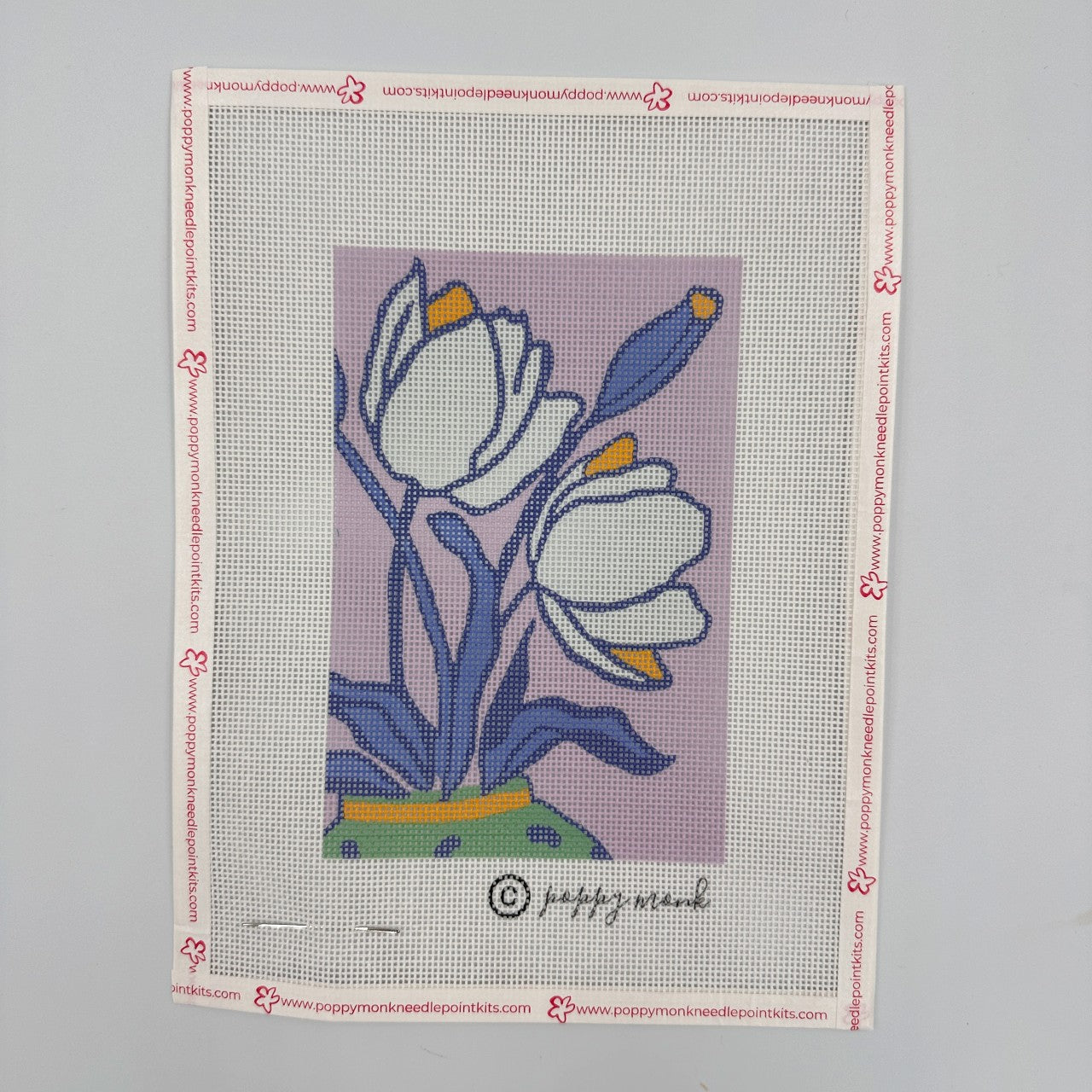 Needlepoint canvas with floral design on a gray background