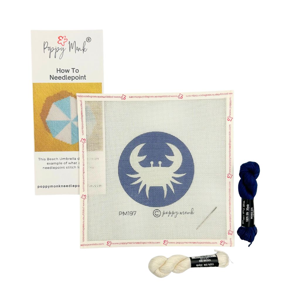 Needlepoint kit with Cancer crab canvas, yarn, and instructions on a white background