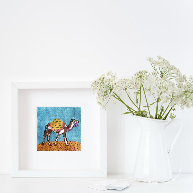 Camel needlepoint design shown in a frame.