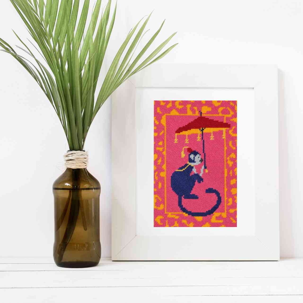 Chinoiserie Monkey needlepoint kit with silk threads shown in a white frame lifestyle image.